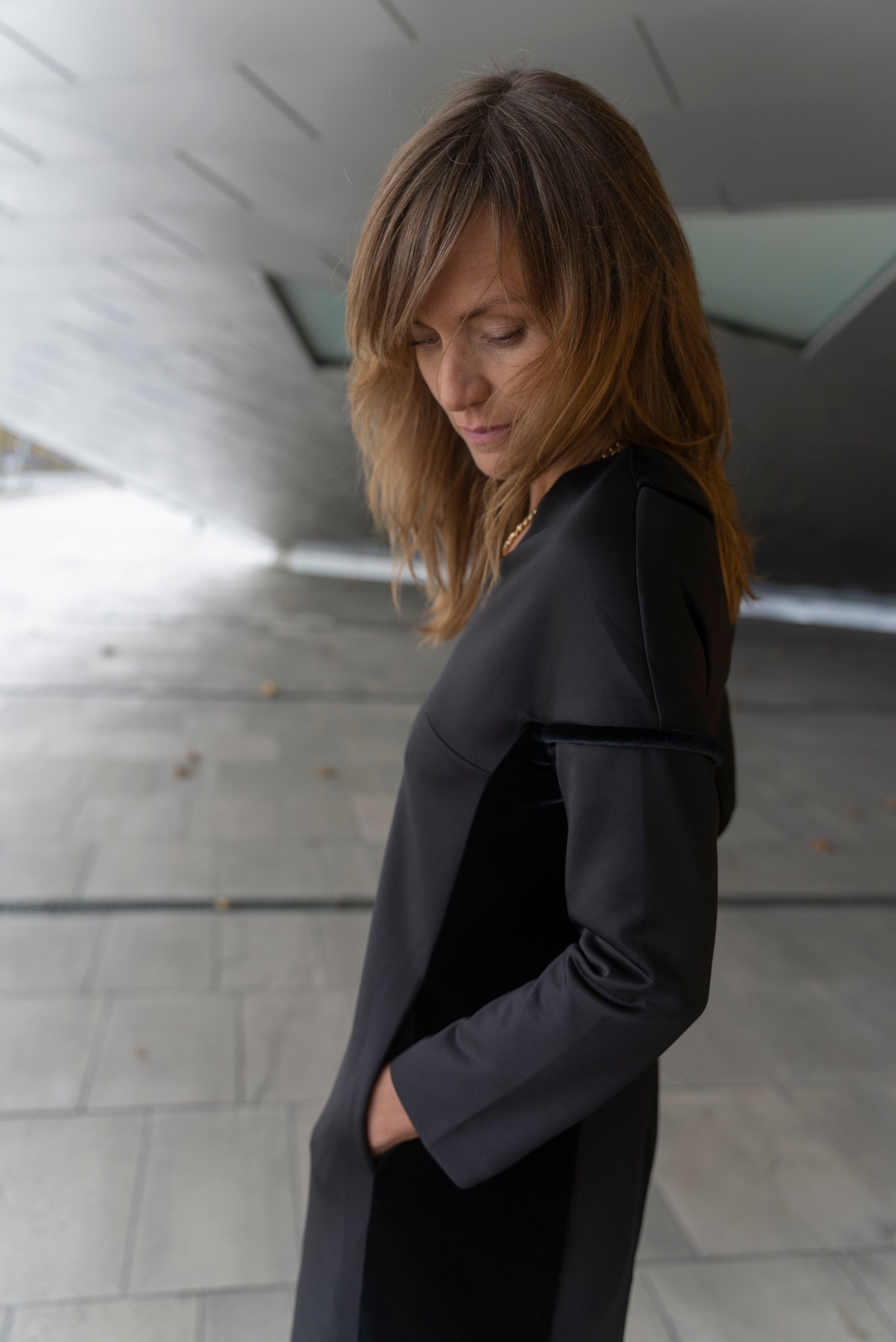 Woman wearing Adisa dress in black - looking down.