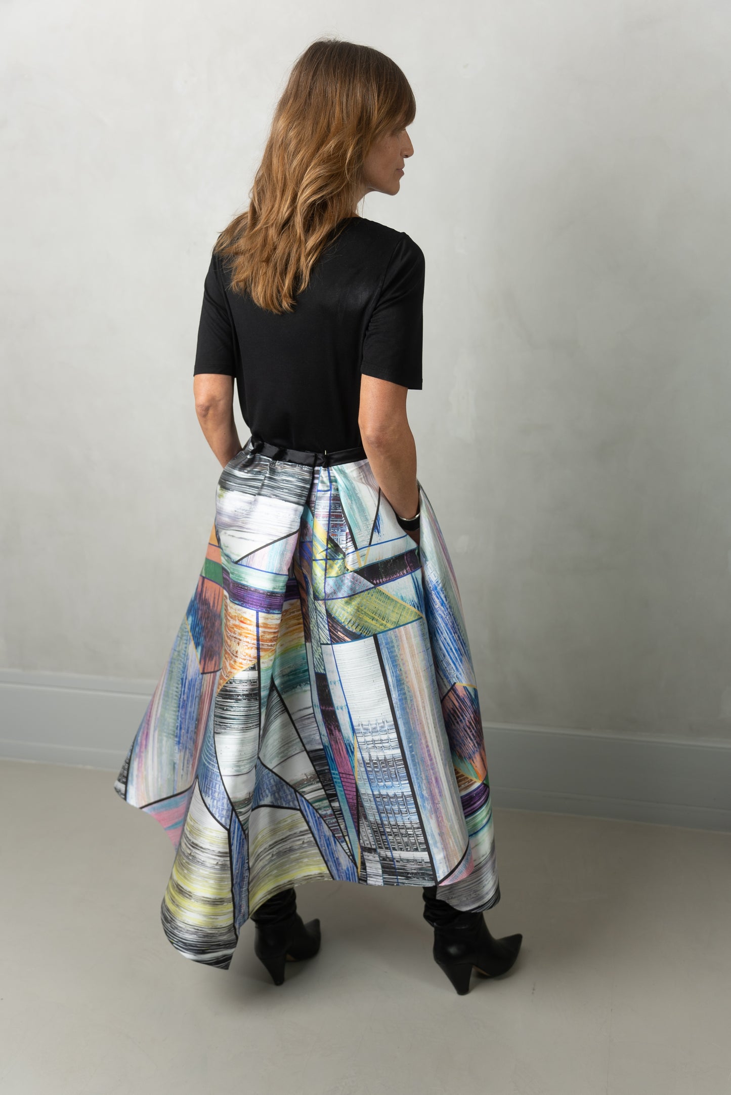 Model wearing Alayan skirt, long city break, & own black t-shirt. Back view.
