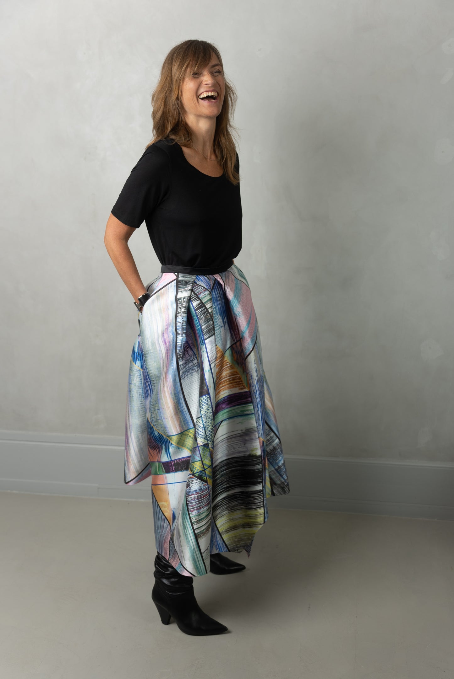 Model laughing wearing Alayan skirt long, city break & own black t-shirt.