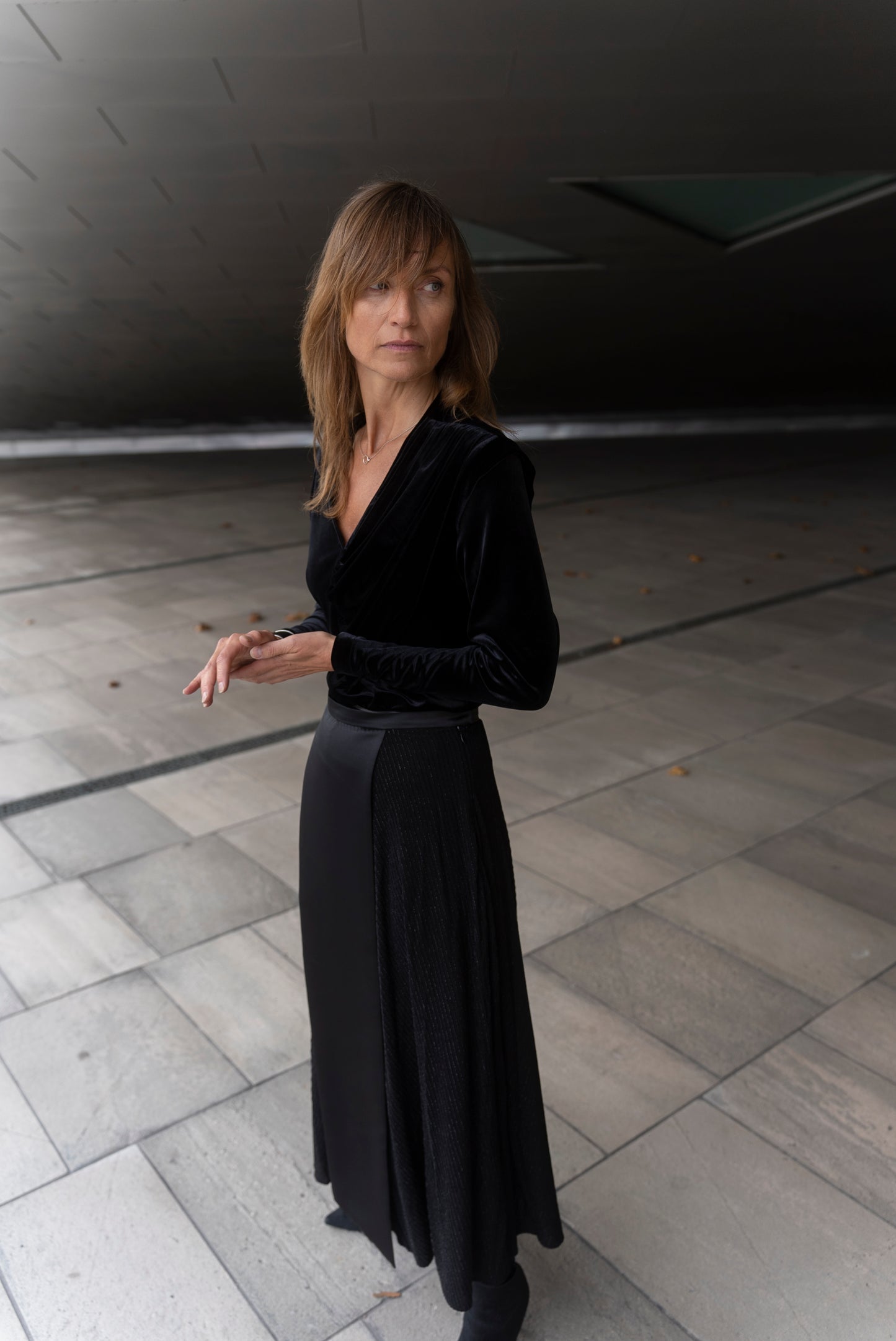 Woman wearing Alek top mathced with Aya skirt - all in black.