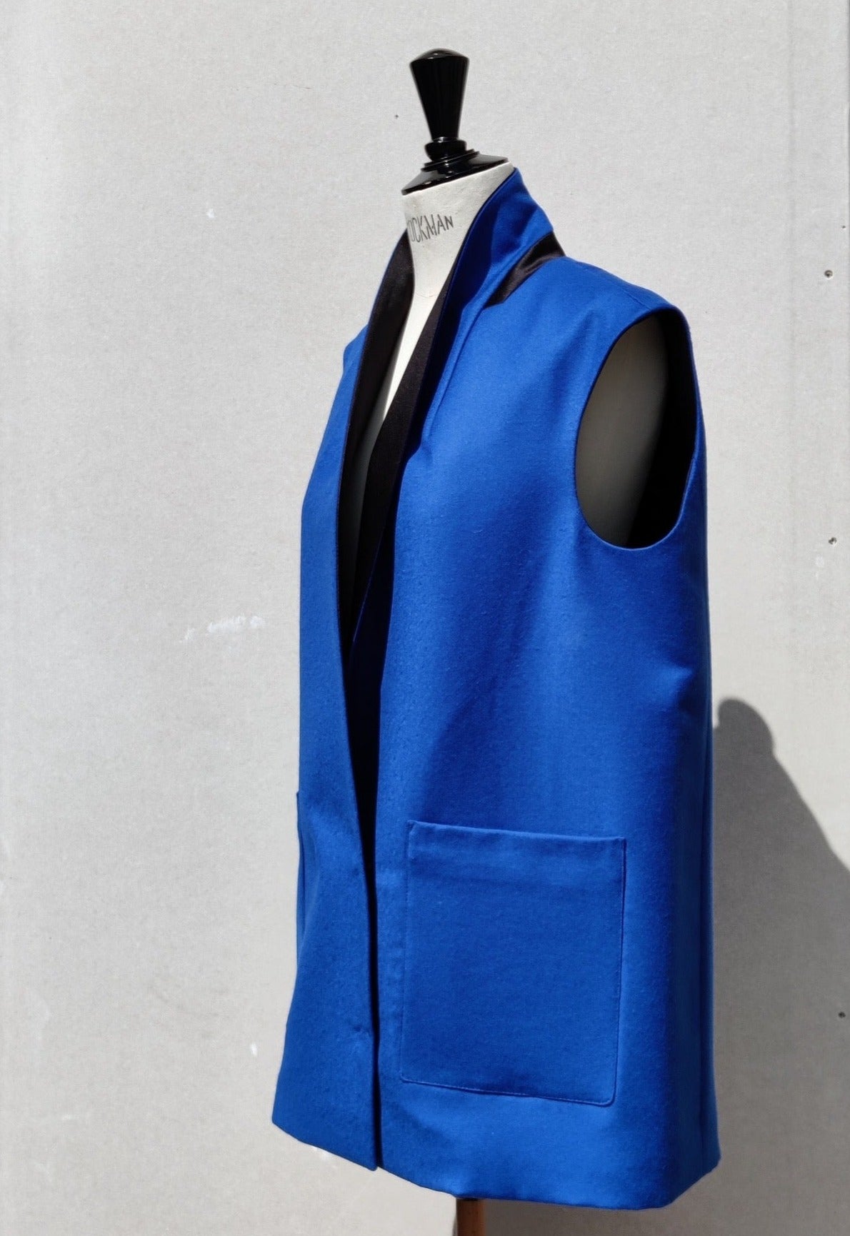 Alson Gilet, blue wool, on a dummy. Side view.