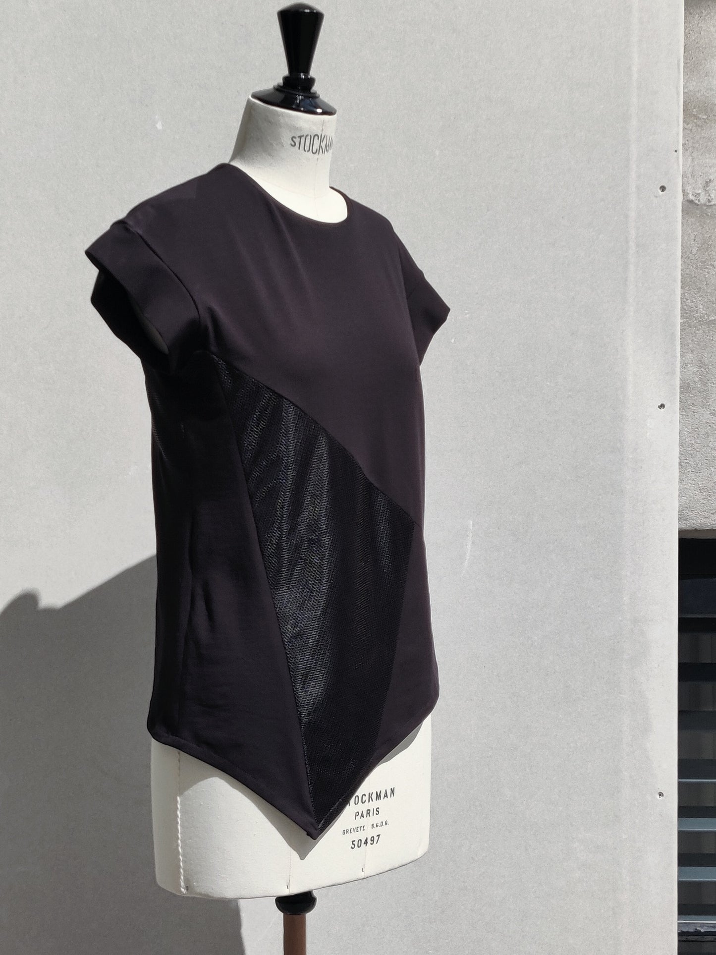 Side view. The Ashlee T-shirt has a cut-out lined mesh detail on the front and a different cut-out lined mesh detail on the back.