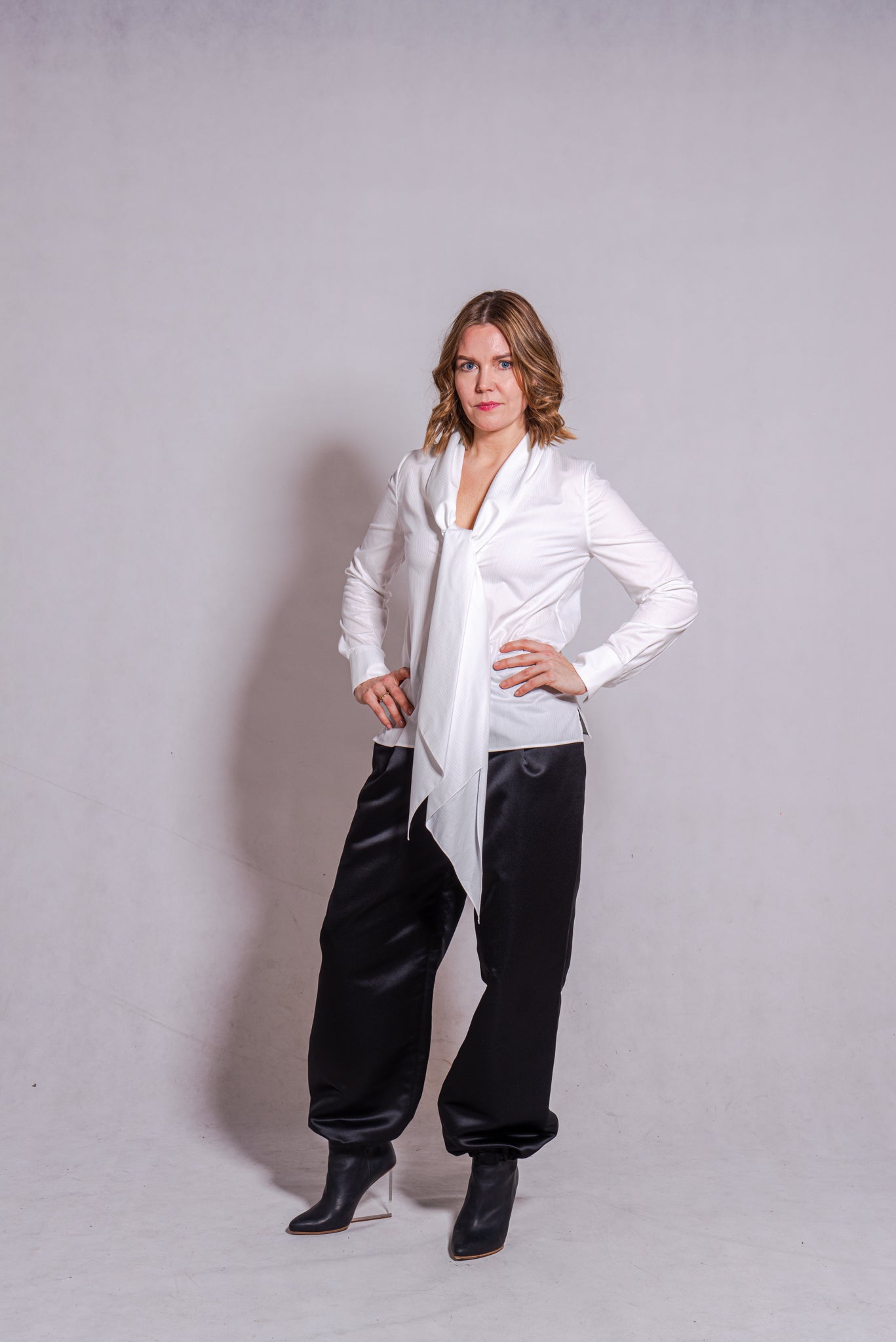 Woman wearing Alina top in white matched with Agnes pants in black.