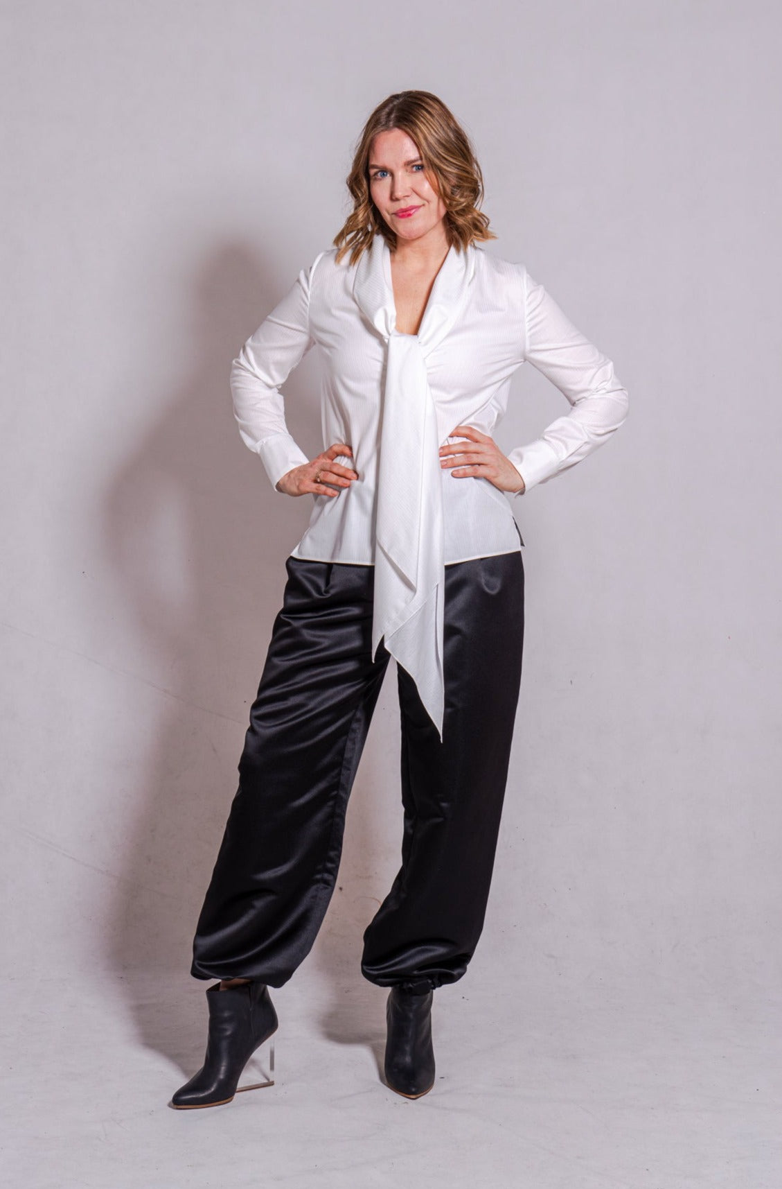 Woman wearing long sleeve Alina in white striped, matched with Agnes pants in black.