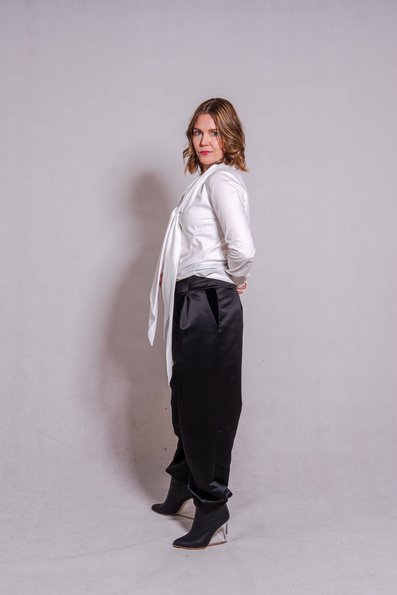 Woman wearing Alina top in white matched with Agnes pants in black.