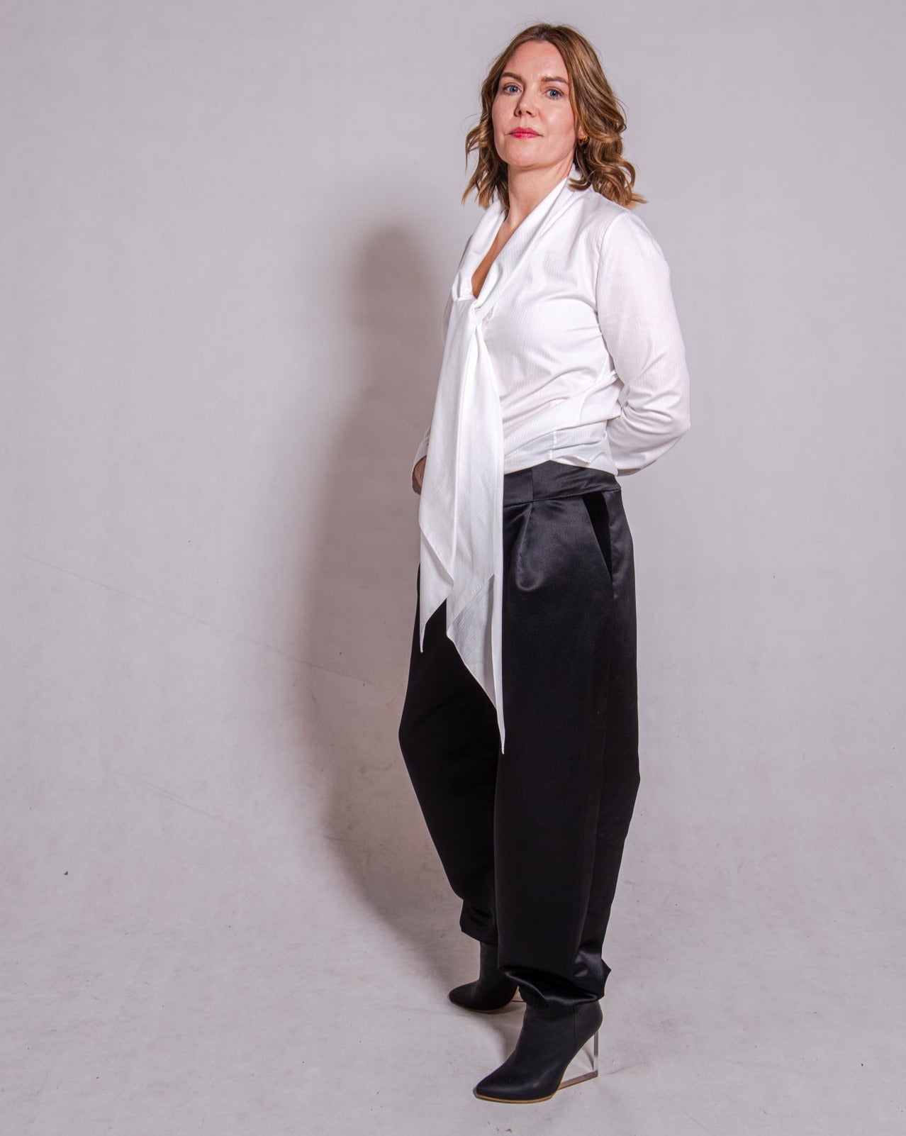 Woman wearing long sleeve Alina in white striped, matched with Agnes pants in black.