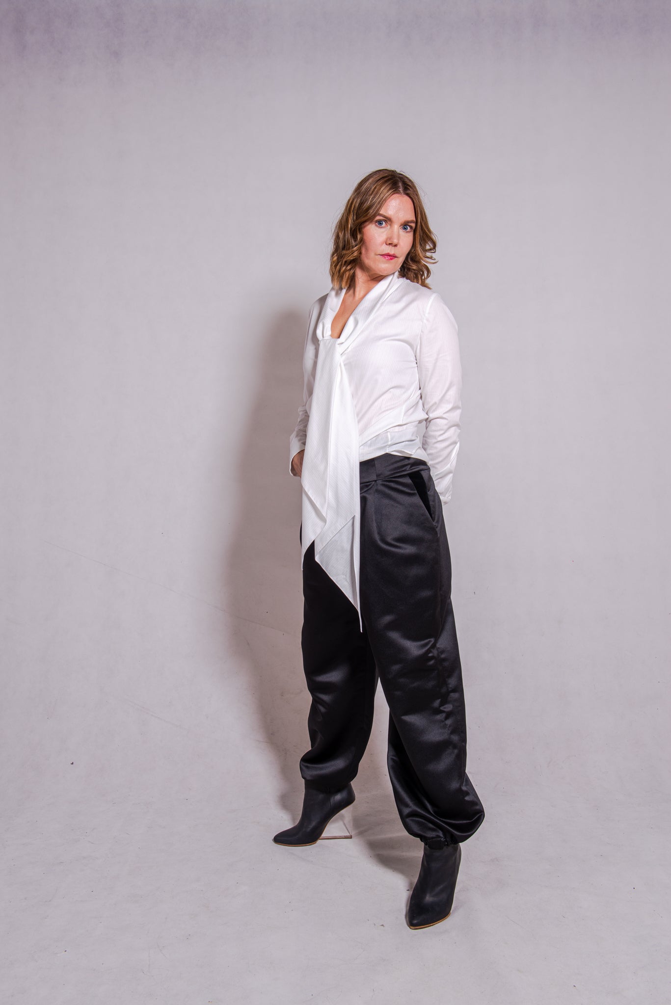 Woman wearing Alina top in white matched with Agnes pants in black.