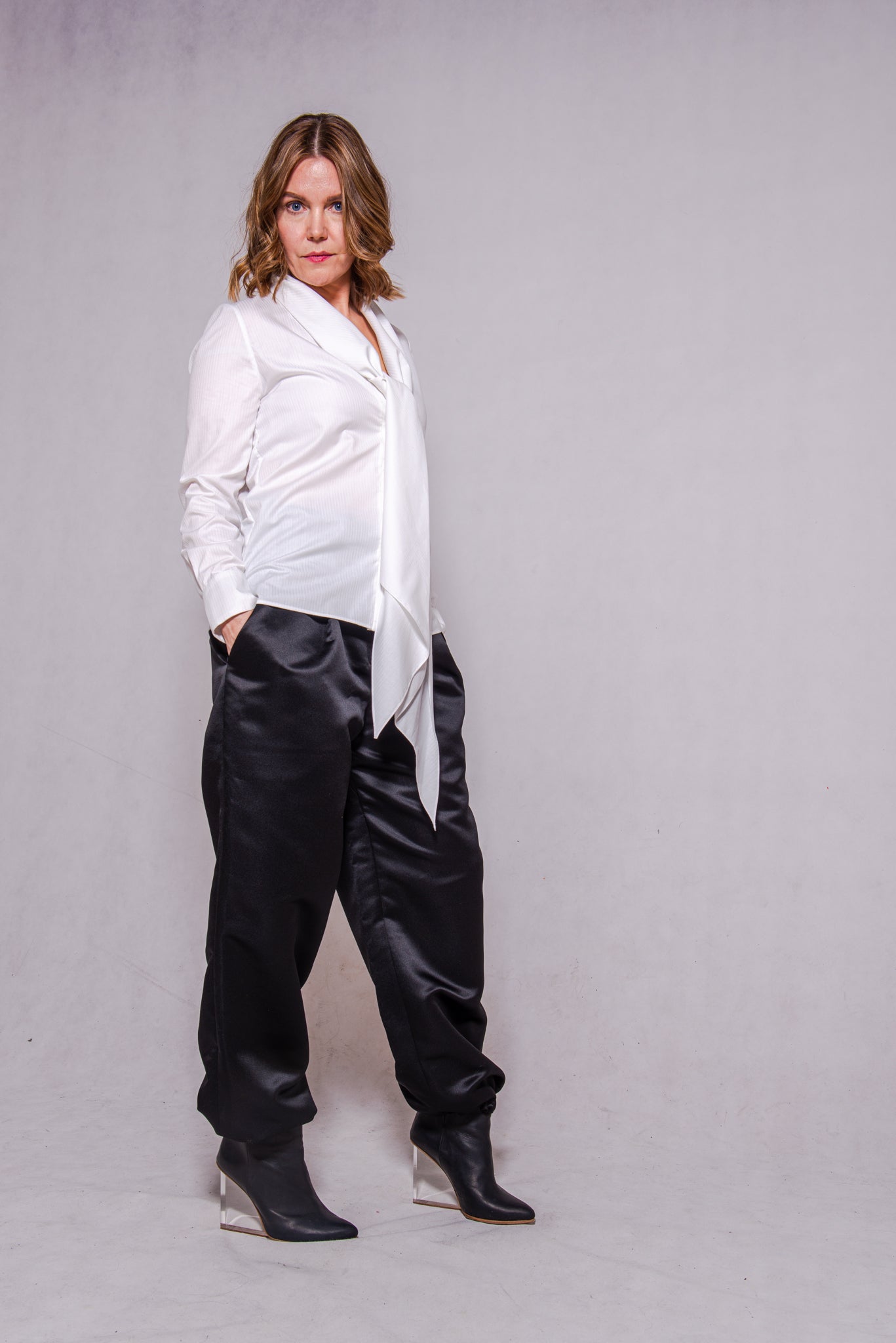 Woman wearing Alina top in white matched with Agnes pants in black.