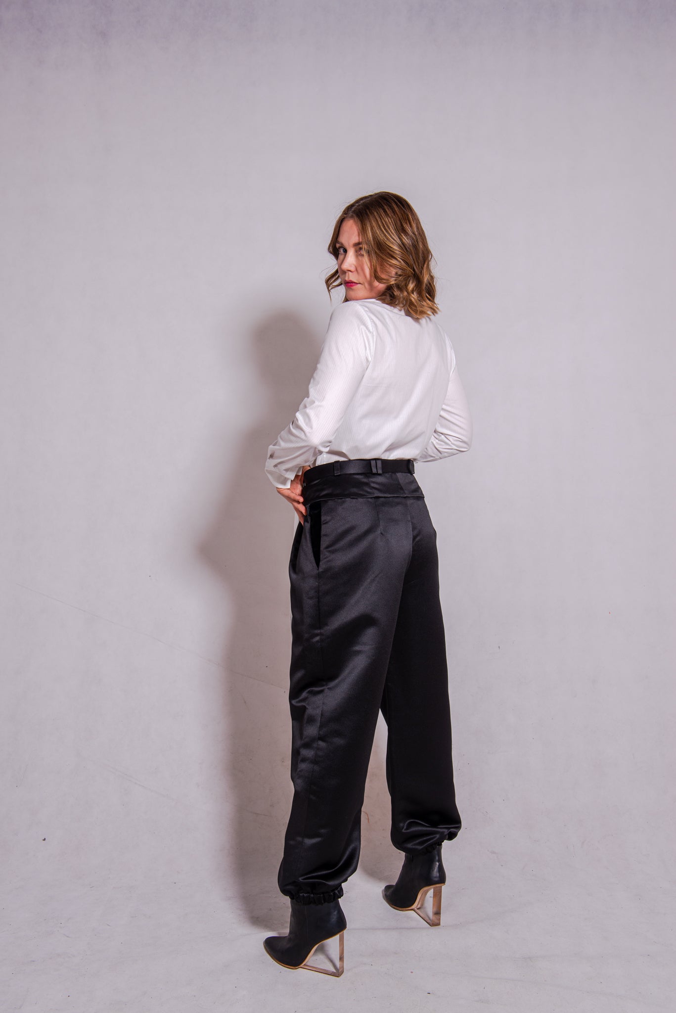 Woman wearing Alina top in white matched with Agnes pants in black.