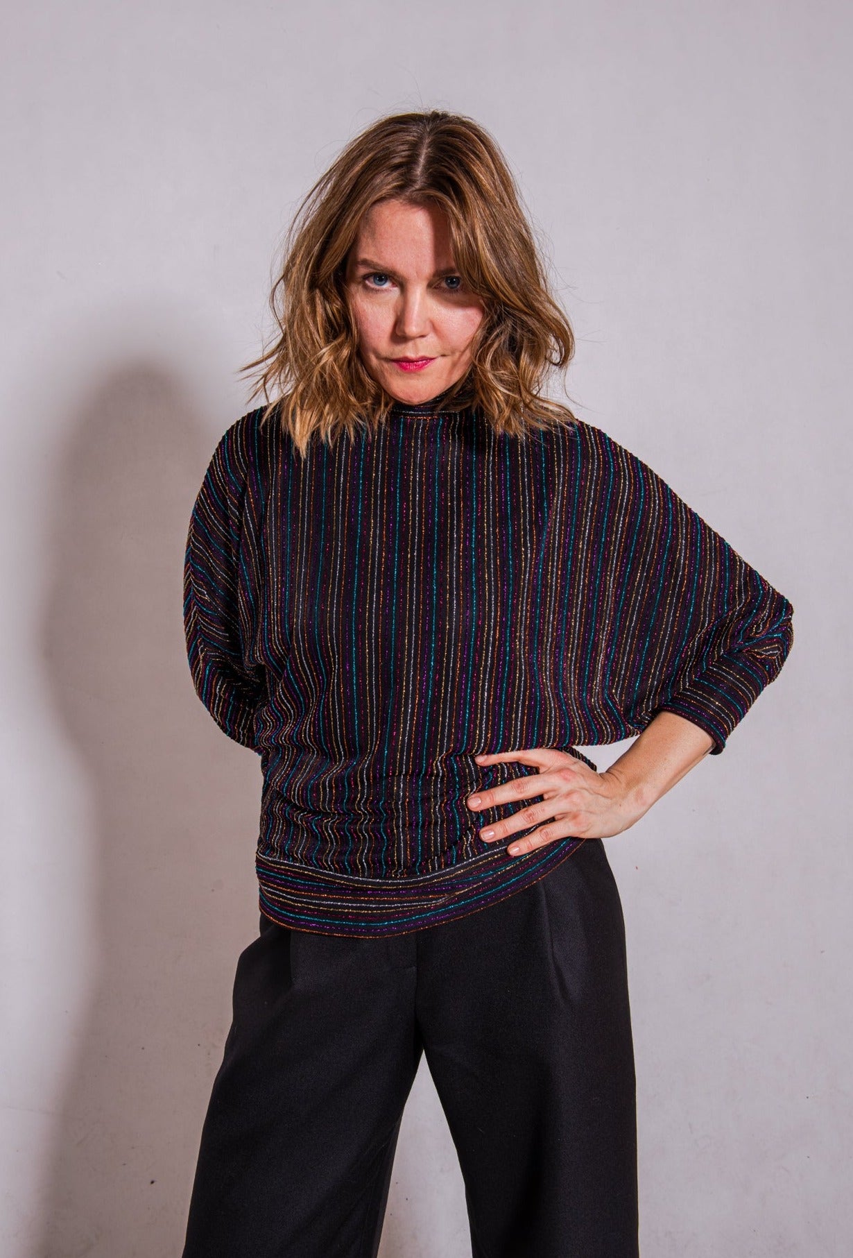Model looking direct wearing Adrianna top, stripey multi & Ava trousers, black.
