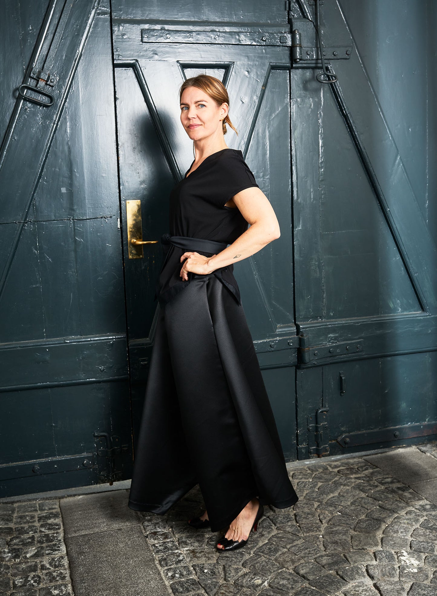 Side view: It has soft pocket bags silk lining and the zip is hidden in drape on the back. Paired here with an Aider top black.