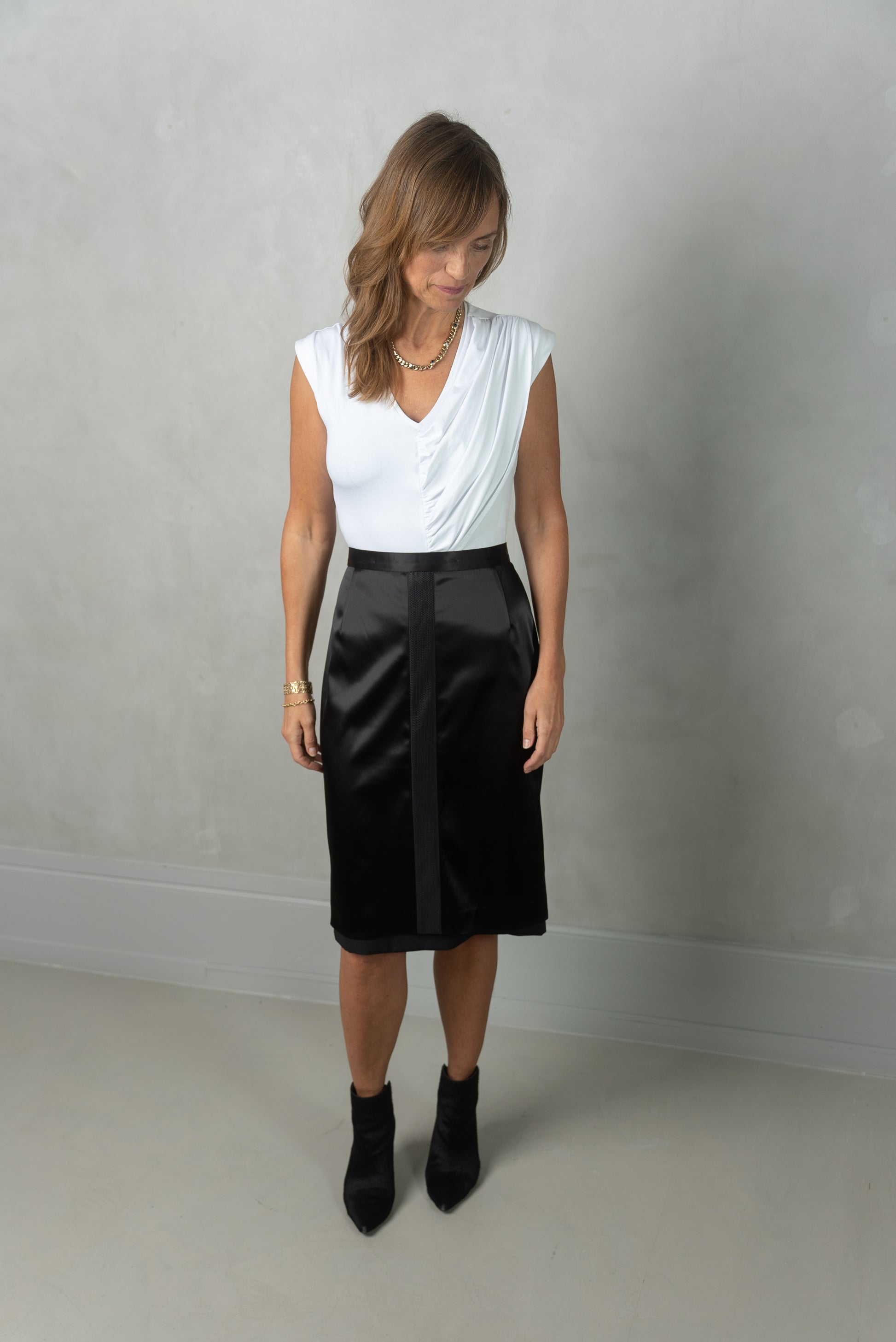 Woman wearing Asra body in white with Annouk skirt in black.