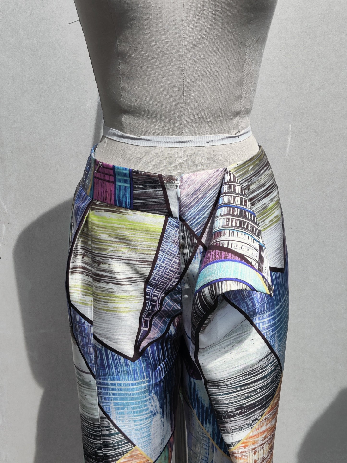 Front detail view. Akiyo pants (multi) front fastening flap & zip detail.