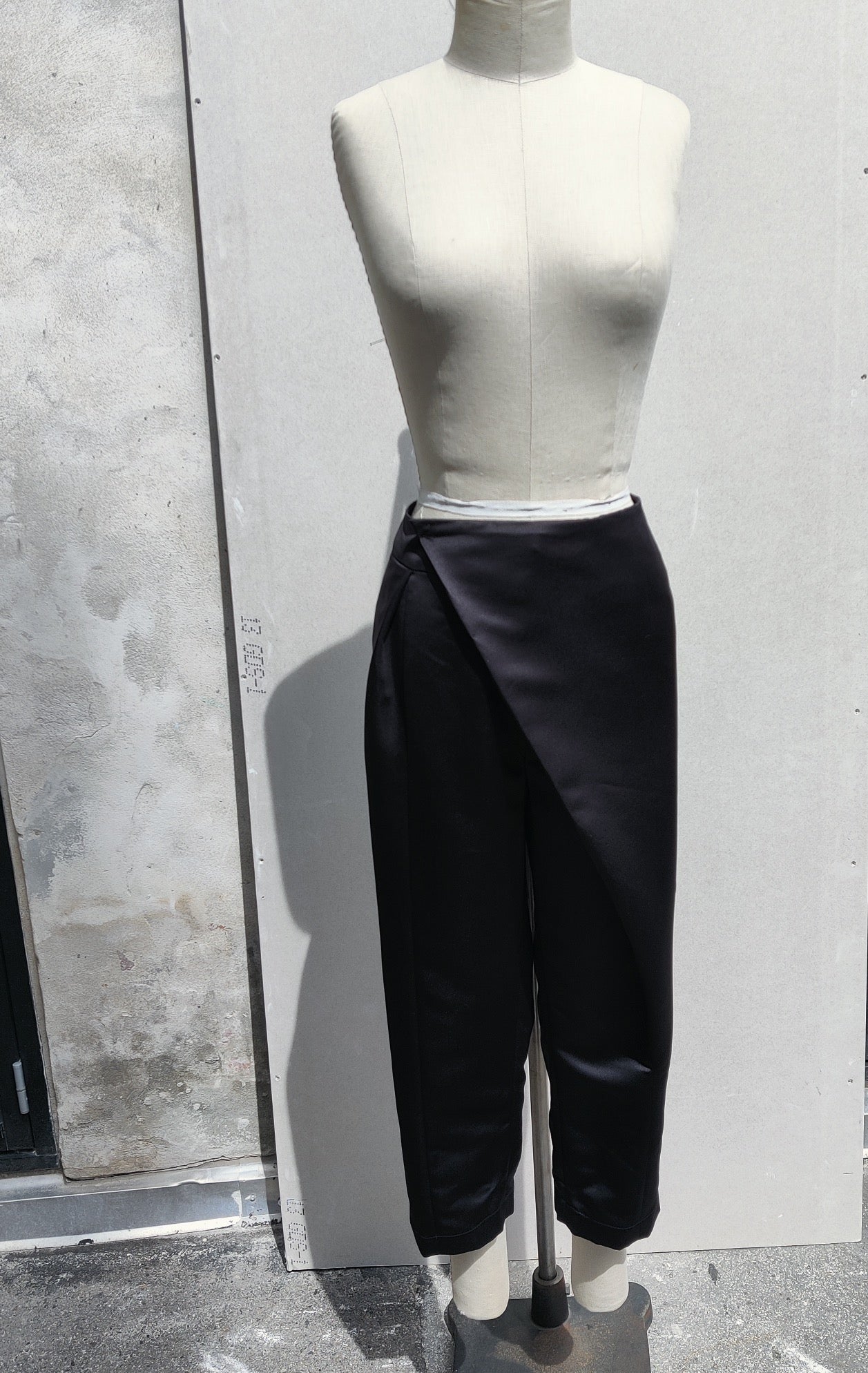 Front view. Akiyo pant (black) is a modern “fisherman” style trouser with cropped length and asymmetric closing