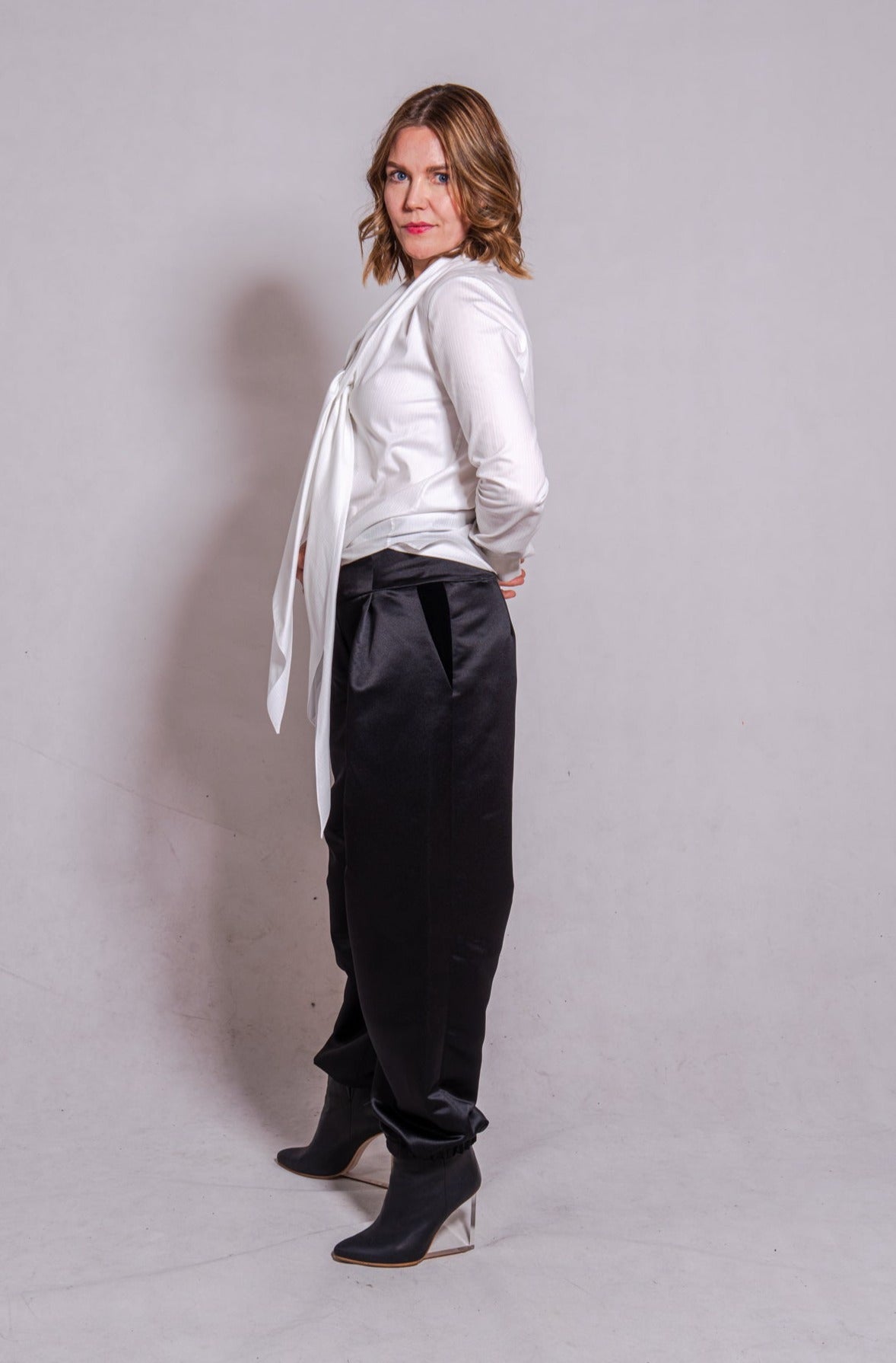 Woman wearing long sleeve Alina in white striped, matched with Agnes pants in black.