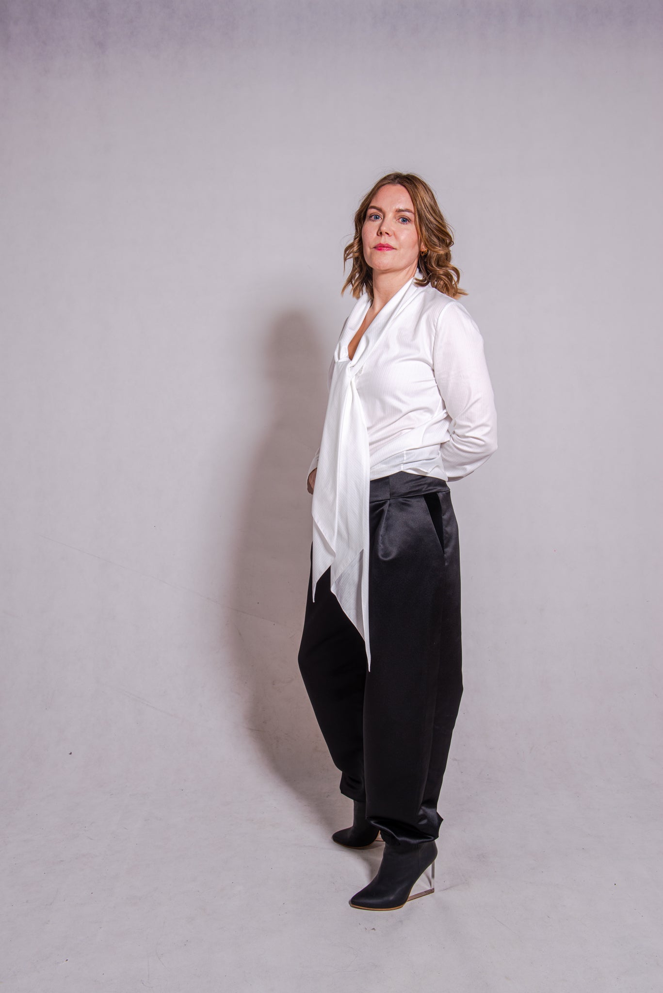 Woman wearing Alina top in white matched with Agnes pants in black.
