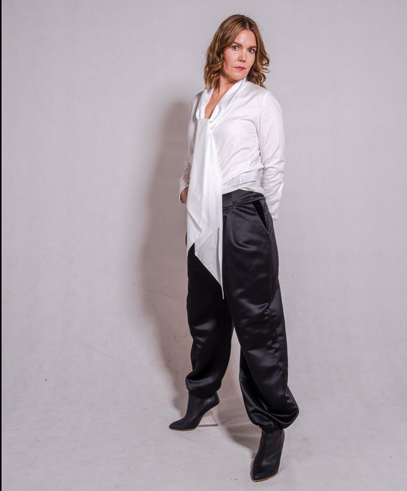 Woman wearing long sleeve Alina in white striped, matched with Agnes pants in black.