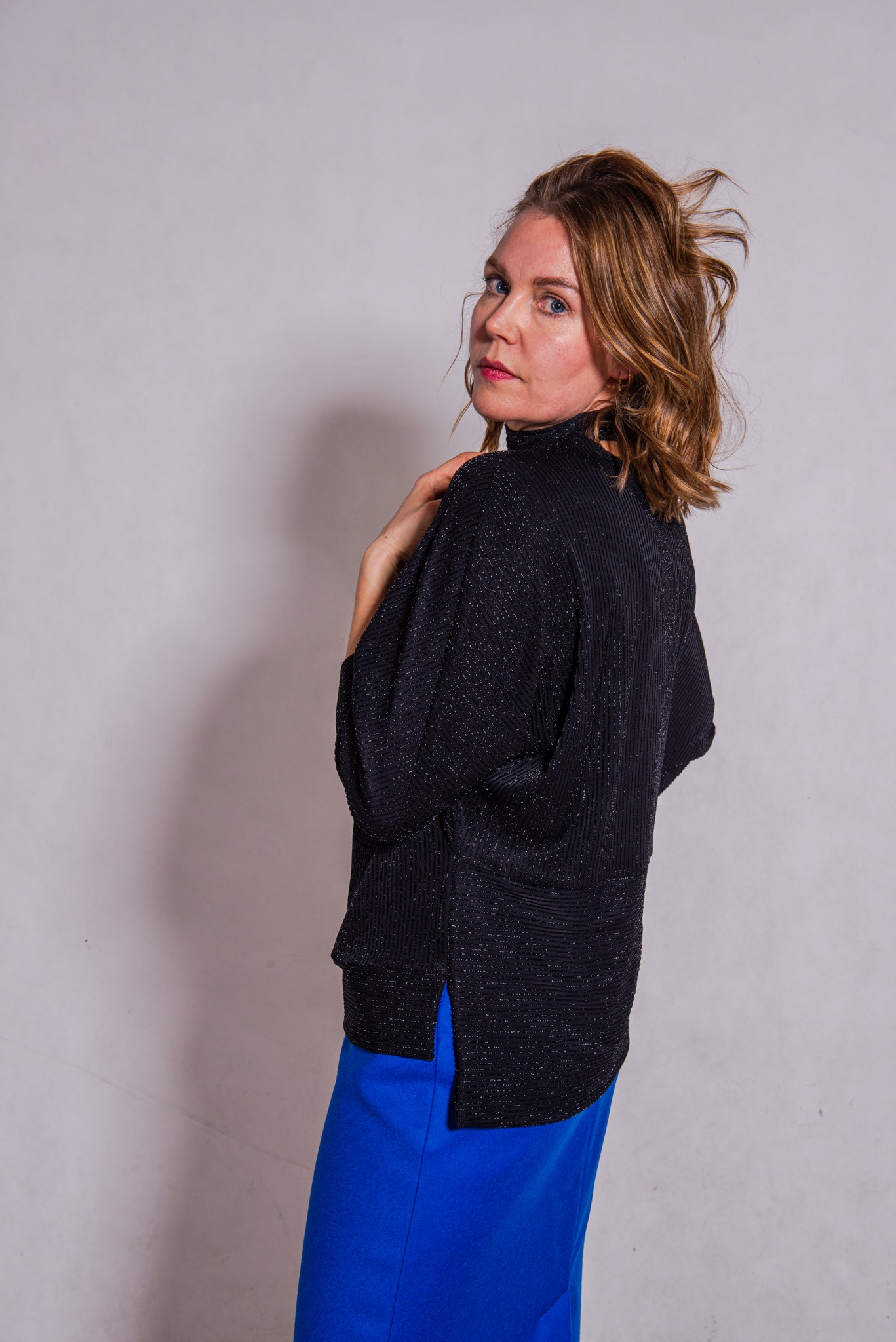 Woman wearing Adriana top with Ava skirt in blue wool.