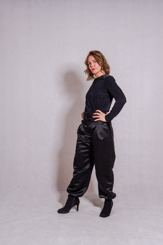 Woman wearing black Ailo top (stripey) with Agnes trousers in black.