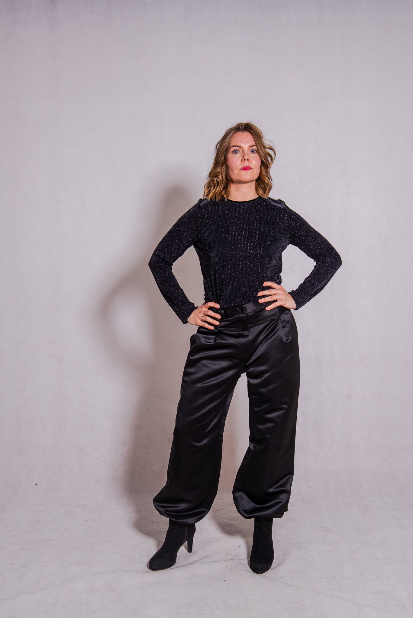 Woman wearing black Ailo top (stripey) with Agnes trousers in black.