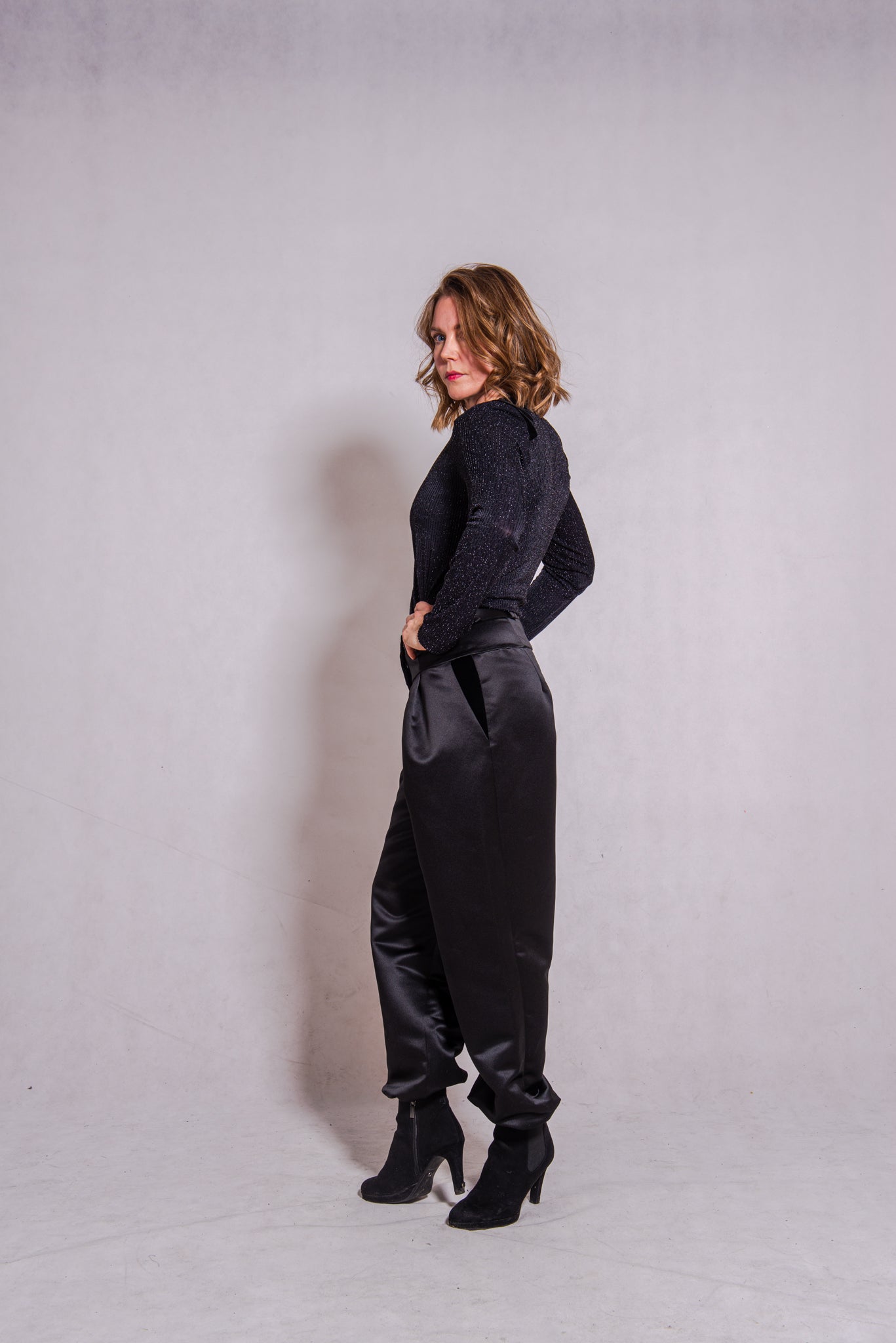Woman wearing black Ailo top (stripey) with Agnes trousers in black.
