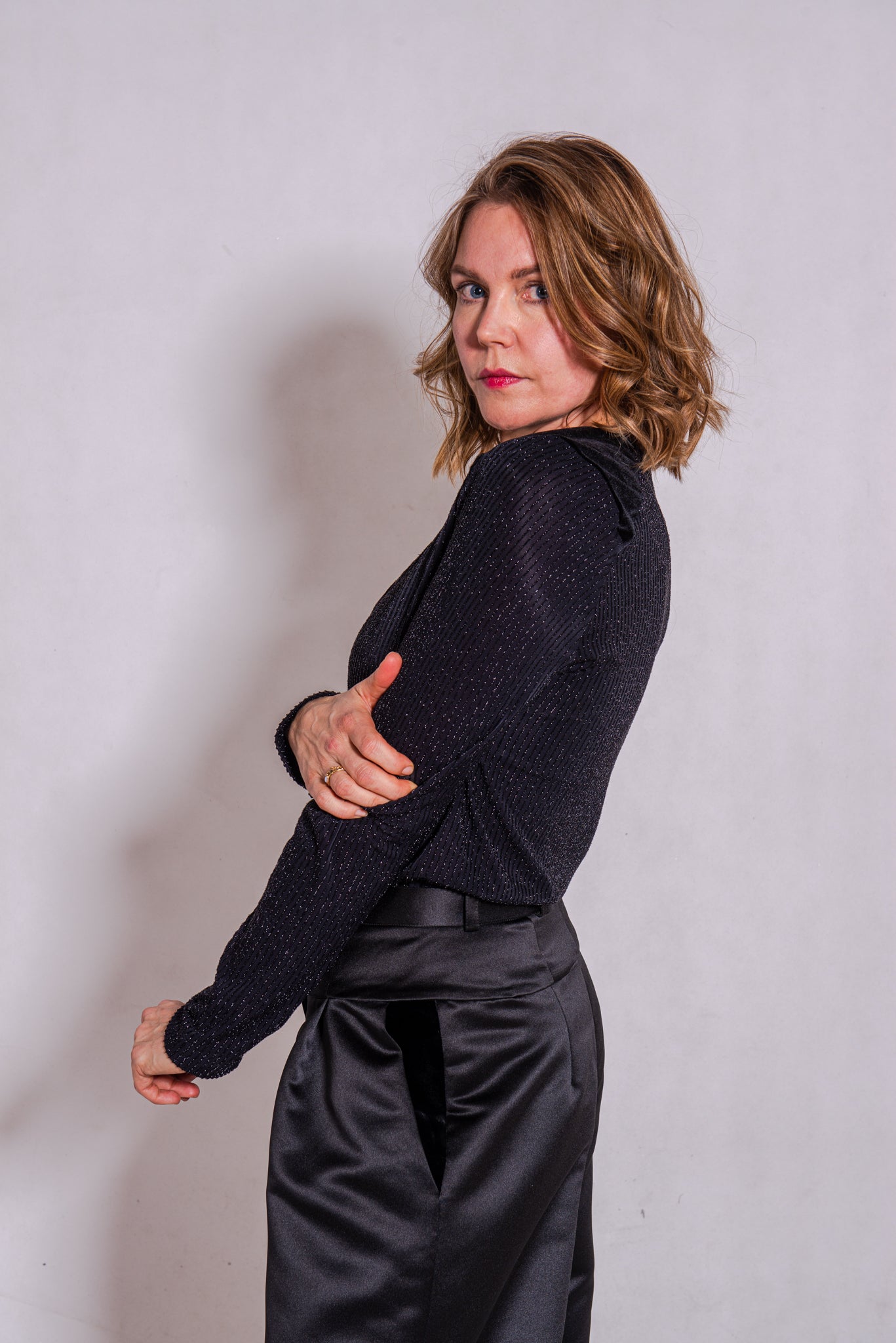 Woman wearing black Ailo top (stripey) with Agnes trousers in black.
